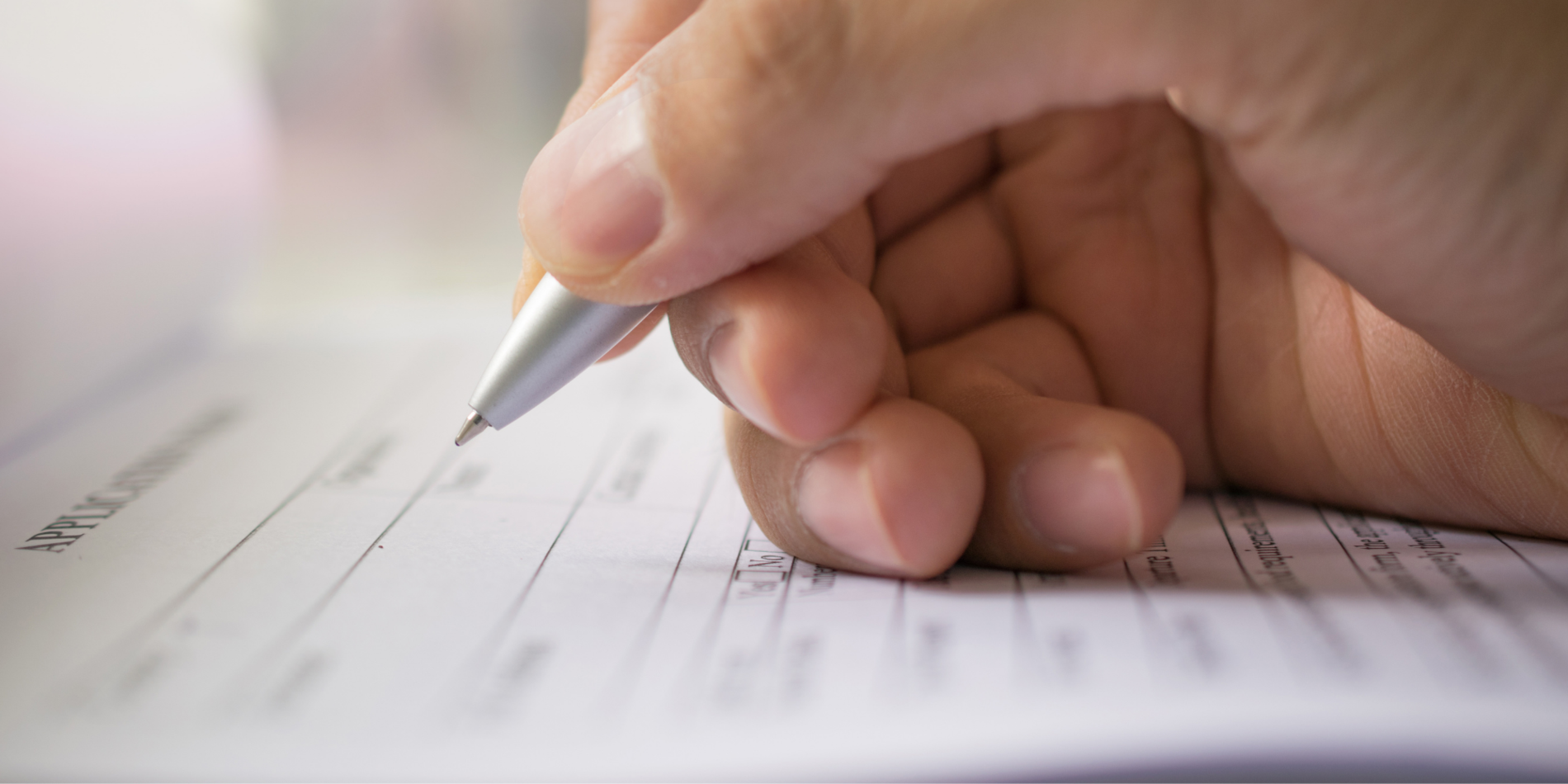 Close up of person signing a form