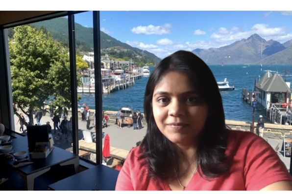 Dishita Patel with virtual background of coffee shop