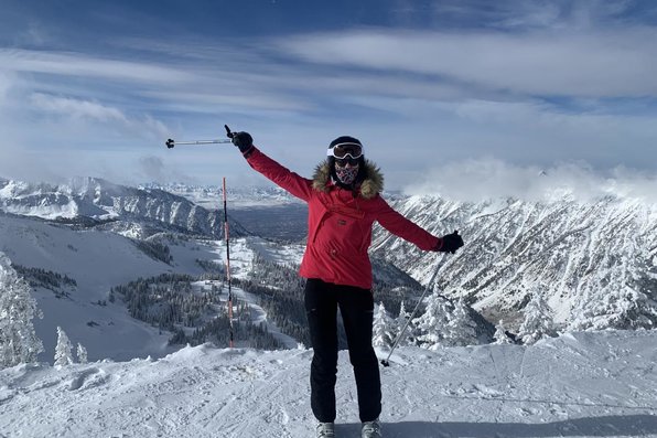 Woman on skis posing on top of mountain