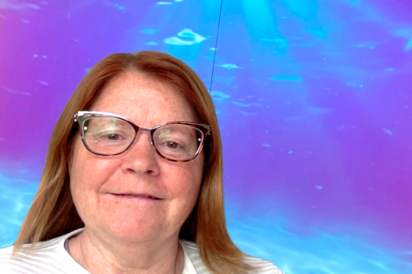 Loretta Gallegos with a virtual background of an under the sea view