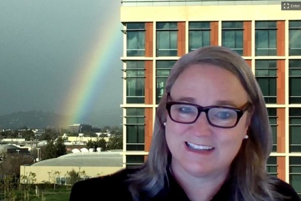 Lucy Kohlmeier with a virtual background of her desk view of university hall