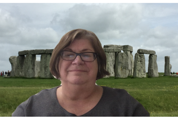 Mary Ayers with a virtual background of stonehenge