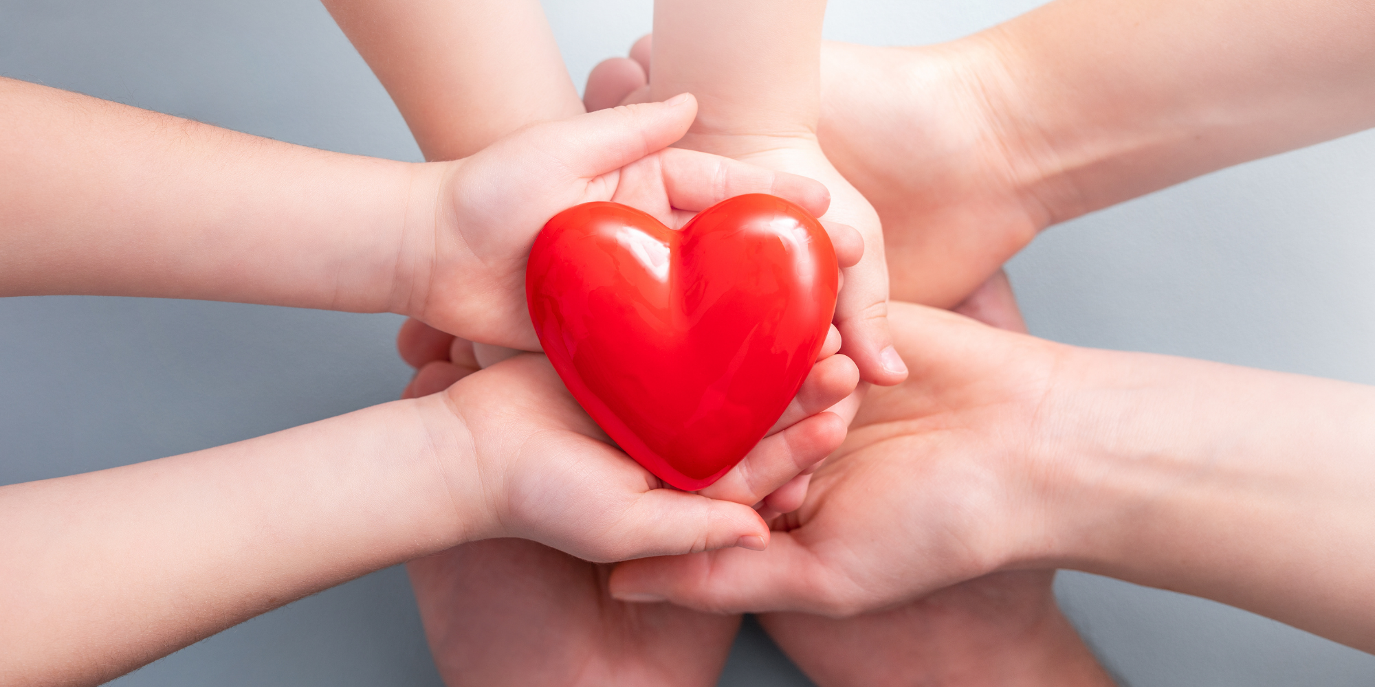 Adult and baby hands holding a heart